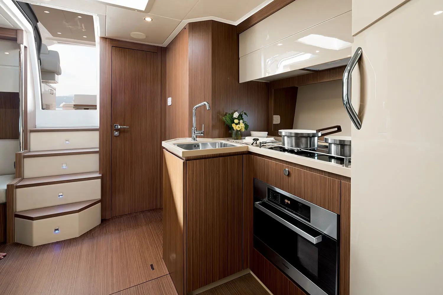Nautische Navigationskarte und Tablet auf einem Teakholztisch der Yacht