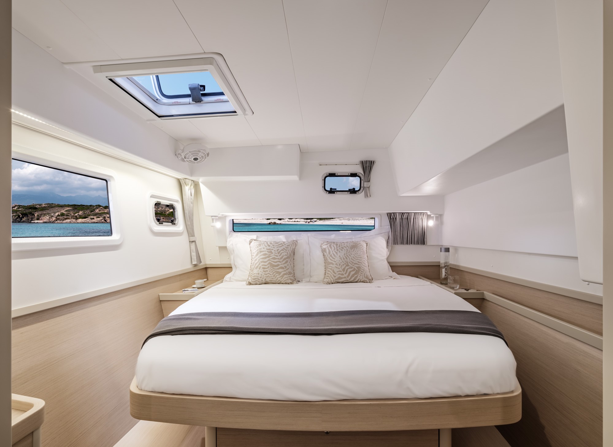 Luxuriöse Katamaran Eignerkabine mit hellem Holz und Panoramafenstern